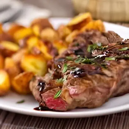 A plate of food with meat and potatoes on it.